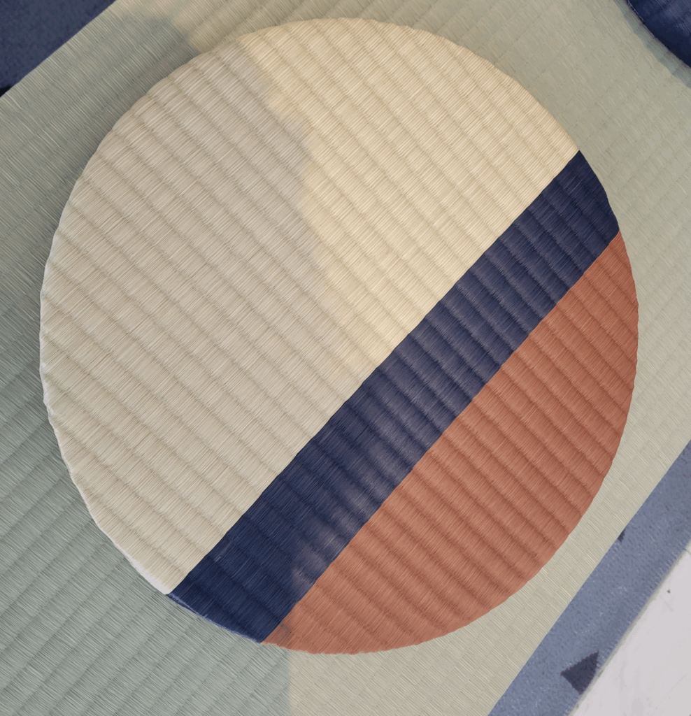 畳ベンチの上においてある、い草の色を途中変えて織ってある丸い畳